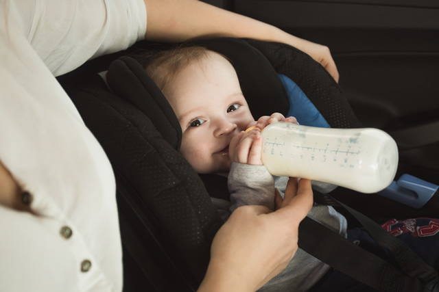 車の中でミルクを飲む赤ちゃん